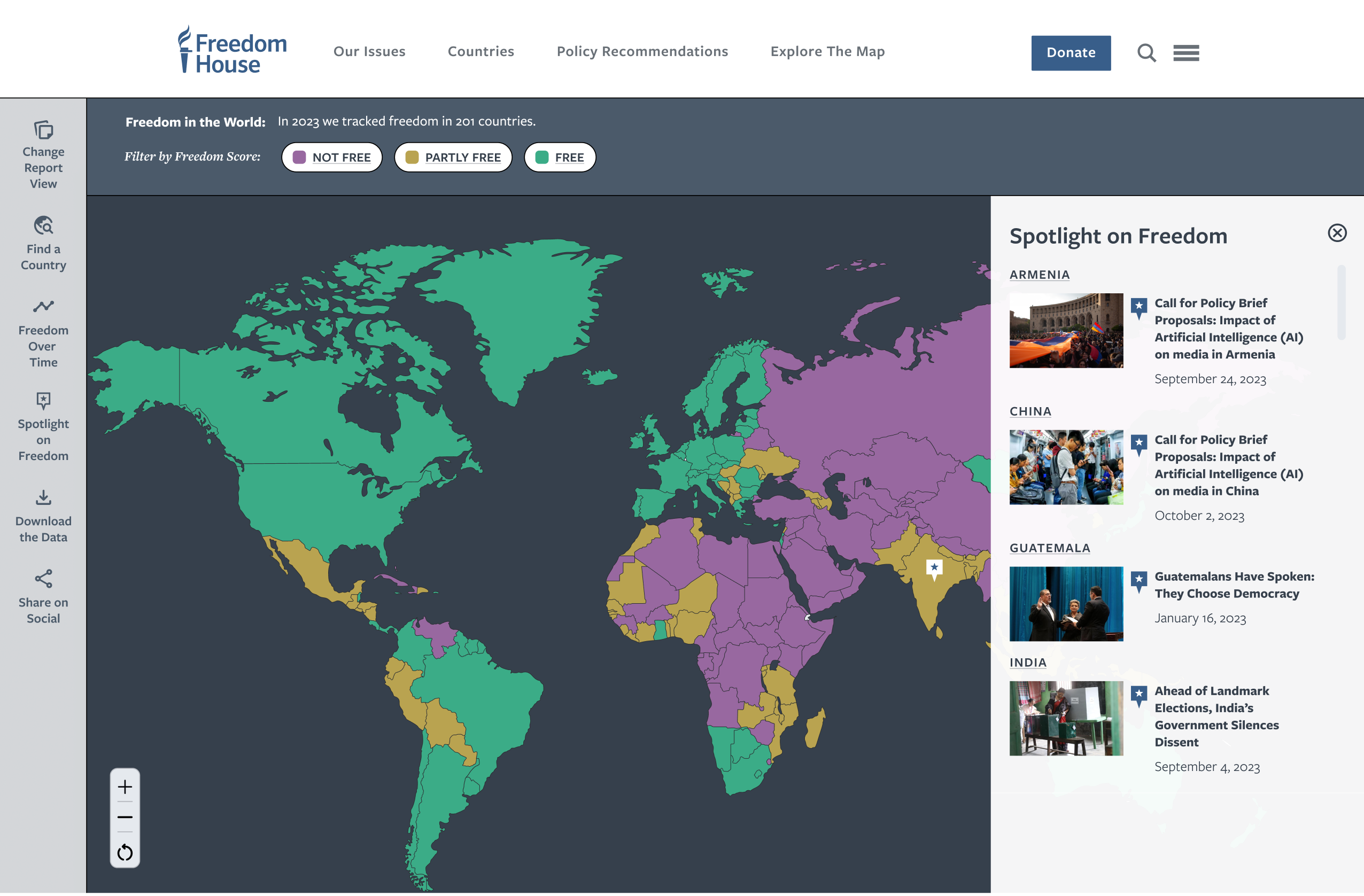 Freedom House interactive world map page titled "Freedom in the World: In 2023 we tracked freedom in 201 countries." Countries are color-coded purple (Not Free), gold (Partly Free), and teal (Free). A left sidebar offers tools including Change Report View, Find a Country, Freedom Over Time, Spotlight on Freedom, Download the Data, and Share on Social. A right panel labeled "Spotlight on Freedom" lists recent articles for Armenia, China, Guatemala, and India.
